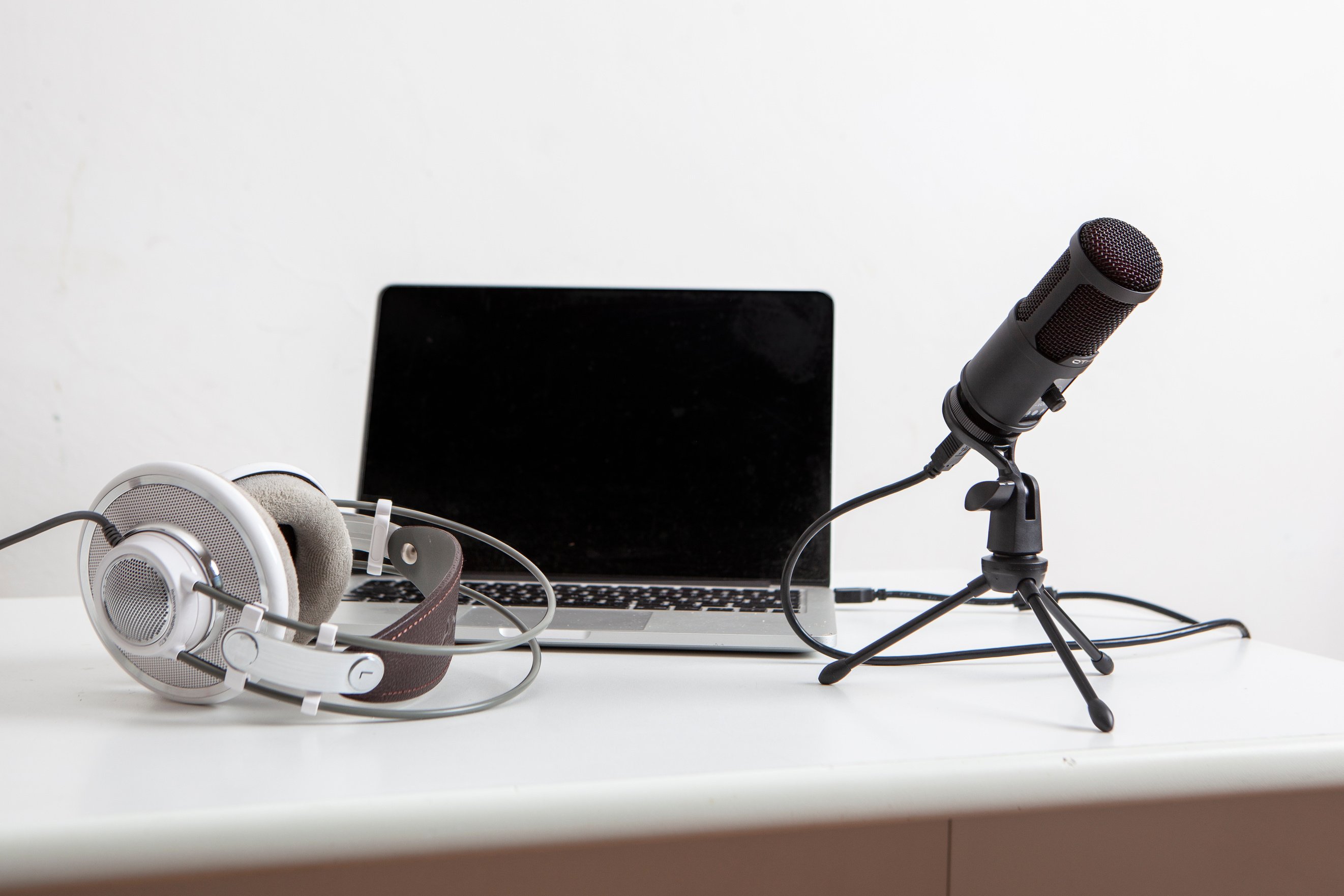Headphones, Microphone and Laptop on White Desk